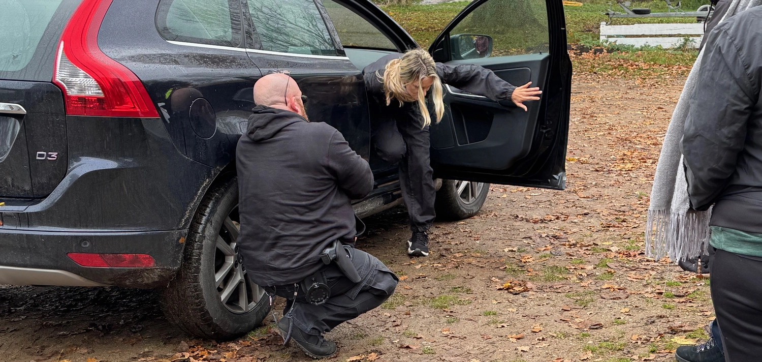 Krisenwerk GmbH -  Crisis management training - Women coming out of the car and man is sitting outside practicing rescue training